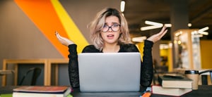 portrait-young-pretty-woman-with-socked-face-expression-sitting-table-working-laptop-co-working-office-wearing-glasses-stress-work-funny-emotion-student-class-room-frustration